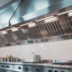 Sparkling clean commercial kitchen exhaust hood in a modern restaurant kitchen, emphasizing safety and efficiency.