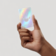 A close-up of a hand holding a rare, holographic Pokémon card in pristine condition, with a clean white background, symbolizing the value and excitement of collecting in India.
