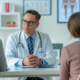 Photorealistic image of a fertility clinic consultation with doctor and patients discussing egg donation in a modern clinical setting with neutral background