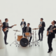 Live wedding band performing at a wedding reception with elegant guests, showcasing a vibrant and joyful celebration atmosphere